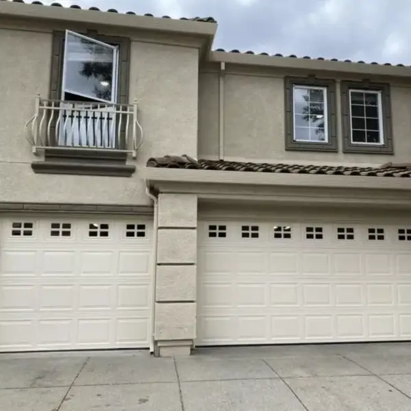 White raised-panel garage doors on a two-story home