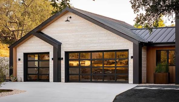 Modern home with black-frame glass garage doors